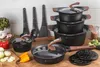 A collection of cookware and kitchen utensils arranged on a wooden surface, with some vegetables and spices in the background. Produktbild-Vorschau
