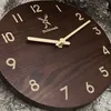 A close-up, angled view of a wooden wall clock with a deer logo and the brand name 'Holzwerk'. Produktbild-Vorschau