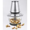 A food chopper with stainless steel and glass components, filled with nuts, sits on a white background with scattered nuts around it. Produktbild-Vorschau