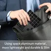A person is placing a black keyboard into a black leather bag. Produktbild-Vorschau