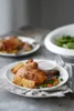 A plate of roasted chicken with potatoes and vegetables, served with a side of sauce. Anteprima dell’immagine prodotto