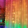 Fairy lights are draped over sheer curtains, creating a colorful and festive atmosphere. Produktbild-Vorschau
