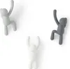 Three wall hooks shaped like stylized human figures are mounted on a white background. Náhled obrázku produktu
