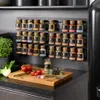 A spice rack with multiple spice jars is mounted on a wall above a kitchen counter. Produktbild-Vorschau