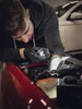 A person working on a car engine with a flashlight. Produktbild-Vorschau