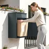 SoBuy Paketbox OGS65-DG in Dark Gray: Frau legt Paket in die Tür des Metallbehälters an Hauswand Vista previa de la imagen del producto