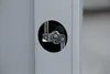 Close-up of a metal bracket and fixture through a circular cutout in a light gray panel. Produktbild-Vorschau