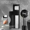 A black toilet paper holder and storage unit mounted on a marble-effect wall, with close-up insets showing how to open it and adjust sensitivity. Podgląd zdjęcia produktu