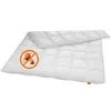 A white quilted duvet or comforter is laid out flat on a white background. There is a circular graphic with a red border and a red diagonal line through it, containing cartoon images of two orange mites. This graphic is placed on the lower left corner of t Produktbild-Vorschau