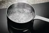 A pot of boiling water on a black induction cooktop. Produktbild-Vorschau