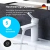 A white bathroom faucet with water running, set against a dark textured background and a blue circular overlay with warranty information. Produktbild-Vorschau