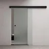 A frosted glass sliding door with a black handle and track, installed on a light gray wall. Anteprima dell’immagine prodotto