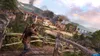 A soldier aims a rifle from a vantage point overlooking a village under attack, with smoke rising from buildings and an airplane in the sky. Náhled obrázku produktu
