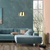 A modern living room with a teal sofa, a large window, and a floor lamp. Anteprima dell’immagine prodotto