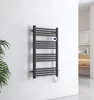 A black electric towel warmer mounted on a marble-tiled wall in a modern bathroom. Náhľad obrázku produktu