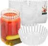 A glass jar filled with red pickled items and two pickles in front of it, surrounded by stacks of white plastic fermentation weights. Produktbild-Vorschau