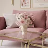 A pink sofa with a floral arrangement on a glass and gold coffee table. Produktbild-Vorschau