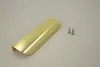 A single gold-colored furniture handle and two screws are placed on a light gray background. Produktbild-Vorschau