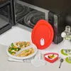 A microwave-safe plate with food, a red lid, and a bottle of water are arranged on a table next to an open microwave. Produktbild-Vorschau