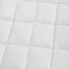 A close-up view of a white quilted blanket or duvet. Produktbild-Vorschau
