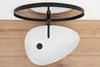 A white oval basin is mounted on a black fixture against a white ceiling and a wooden wall. Anteprima dell’immagine prodotto