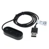 A black USB charging cable and adapter for a fitness tracker. Produktbild-Vorschau
