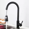 A black kitchen faucet with a pull-down sprayer is shown in a kitchen sink. Produktbild-Vorschau