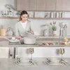 A woman is cooking in a modern kitchen, with a dining table set in the foreground. Voir les images du produit