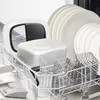 A dishwasher rack with various kitchen items, including plates, a food processor attachment, and a basket. Produktbild-Vorschau