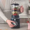 A person is holding a blender filled with fruit, with various features labeled. Produktbild-Vorschau