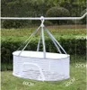 A white mesh drying basket hanging from a bar outdoors. Náhľad obrázku produktu