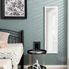 A bedroom scene with a bed, a mirror, and a side table. Produktbild-Vorschau