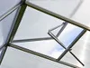 Close-up view of the interior of a greenhouse, showing the frame and an open automatic window. Produktbild-Vorschau