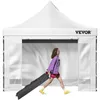 A woman walks past a white pop-up tent, pulling a black carrying bag with wheels. Voir les images du produit