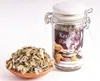 A jar of herbal incense blend next to a small clay bowl filled with the same blend, on a white background. Produktbild-Vorschau