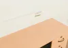 A close-up view of a desk with a light wood finish and a white wall in the background. There are three colored lines (blue, red, green) on the wall. Náhled obrázku produktu