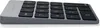 A close-up, angled view of a gray and black Satechi aluminum wireless numeric keypad against a white background. Voir les images du produit