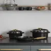 A collection of black Staub cast iron cookware, including pots and a frying pan, displayed on a dark countertop. Náhled obrázku produktu