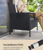 A person sitting on a black rattan chair on a patio, holding a mug. Produktbild-Vorschau