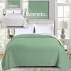 A collage showing a green bedspread on a bed in a bedroom setting, and a white bedspread on a bed in a similar setting, with a marketing graphic above. Produktbild-Vorschau