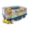 A fruit dehydrator filled with various sliced fruits, with some fresh fruits in the foreground. Podgląd zdjęcia produktu