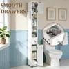 A tall, narrow white cabinet filled with bathroom products is shown next to a toilet in a bathroom setting. A close-up inset shows the contents of a drawer. Produktbild-Vorschau