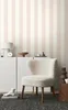 A cozy living room scene with a fluffy chair and a striped wallpaper. Produktbild-Vorschau