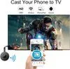 A hand holds a smartphone displaying a screen mirroring icon, with a TV screen in the background showing a movie scene. A small black device is connected to the TV via HDMI. Produktbild-Vorschau