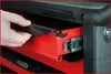 A hand is shown opening a drawer on a red and black tool chest. Produktbild-Vorschau