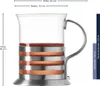 A clear product shot of a glass teacup with metal and wood accents, featuring measurement annotations. Produktbild-Vorschau