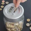 A hand is inserting a coin into a digital piggy bank, which is filled with coins. Náhľad obrázku produktu