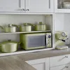 A kitchen counter with appliances and cookware. Voir les images du produit
