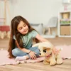 A young girl is playing with a stuffed dog on the floor. Anteprima dell’immagine prodotto