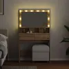 A vanity table with a lighted mirror and a stool in a bedroom setting. Podgląd zdjęcia produktu